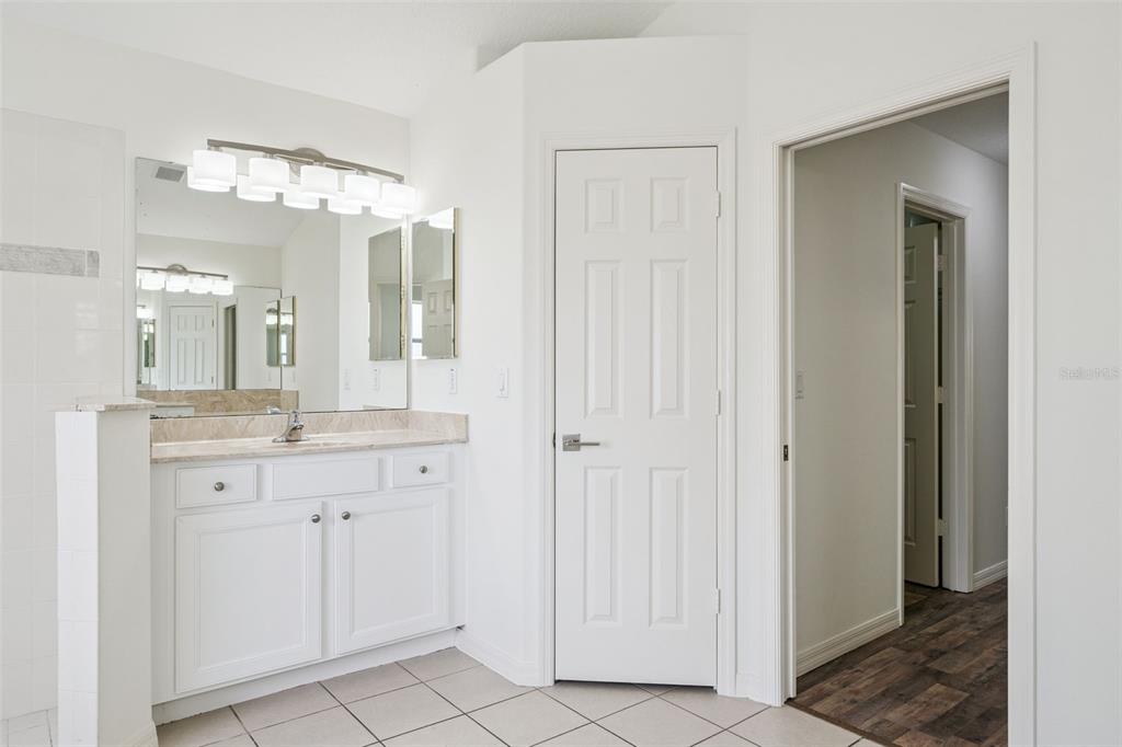 2440 Holly Ridge Court Clermont, FL 34711 - Photo 35 of 43 a bathroom with a granite countertop sink two mirror and a