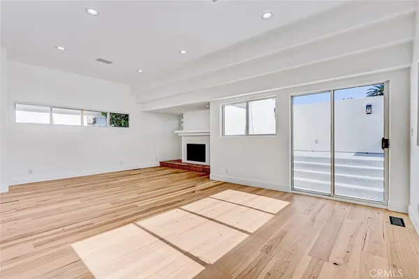 a view of empty room with wooden floor and windows