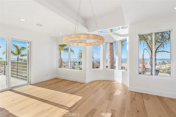 a view of a room with a chandelier fan and wooden floor