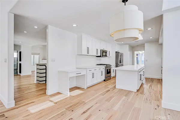 a kitchen that has a lot of cabinets in it and wooden floors