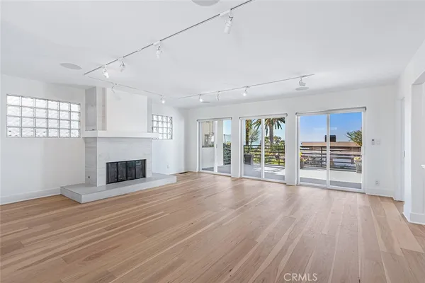 a view of empty room with wooden floor and fireplace