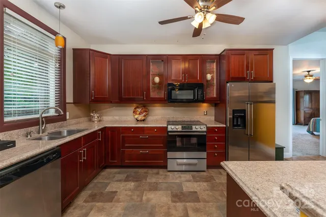 a kitchen with stainless steel appliances granite countertop wooden cabinets a stove top oven a sink and dishwasher