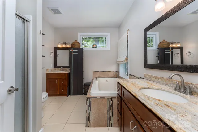 a en suite bathroom with a granite countertop sink and a mirror