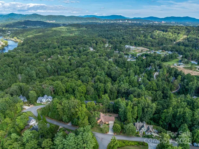 an aerial view of residential houses with outdoor space and trees