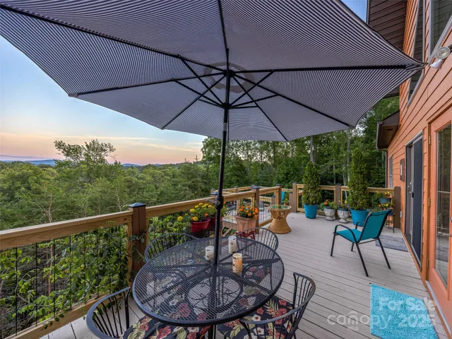 a view of a patio with couches table and chairs under an umbrella