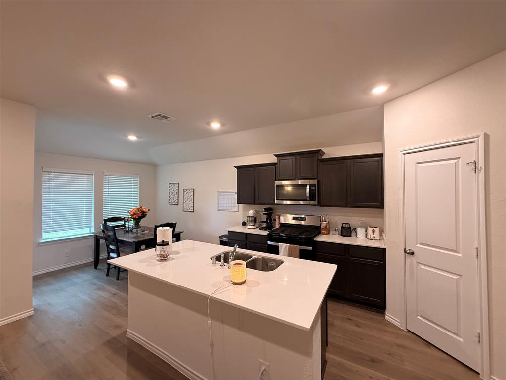 2332 Burleson Road Sherman, TX 75090 - Photo 7 of 21 a view of a kitchen with kitchen island a sink a stove and a refrigerator