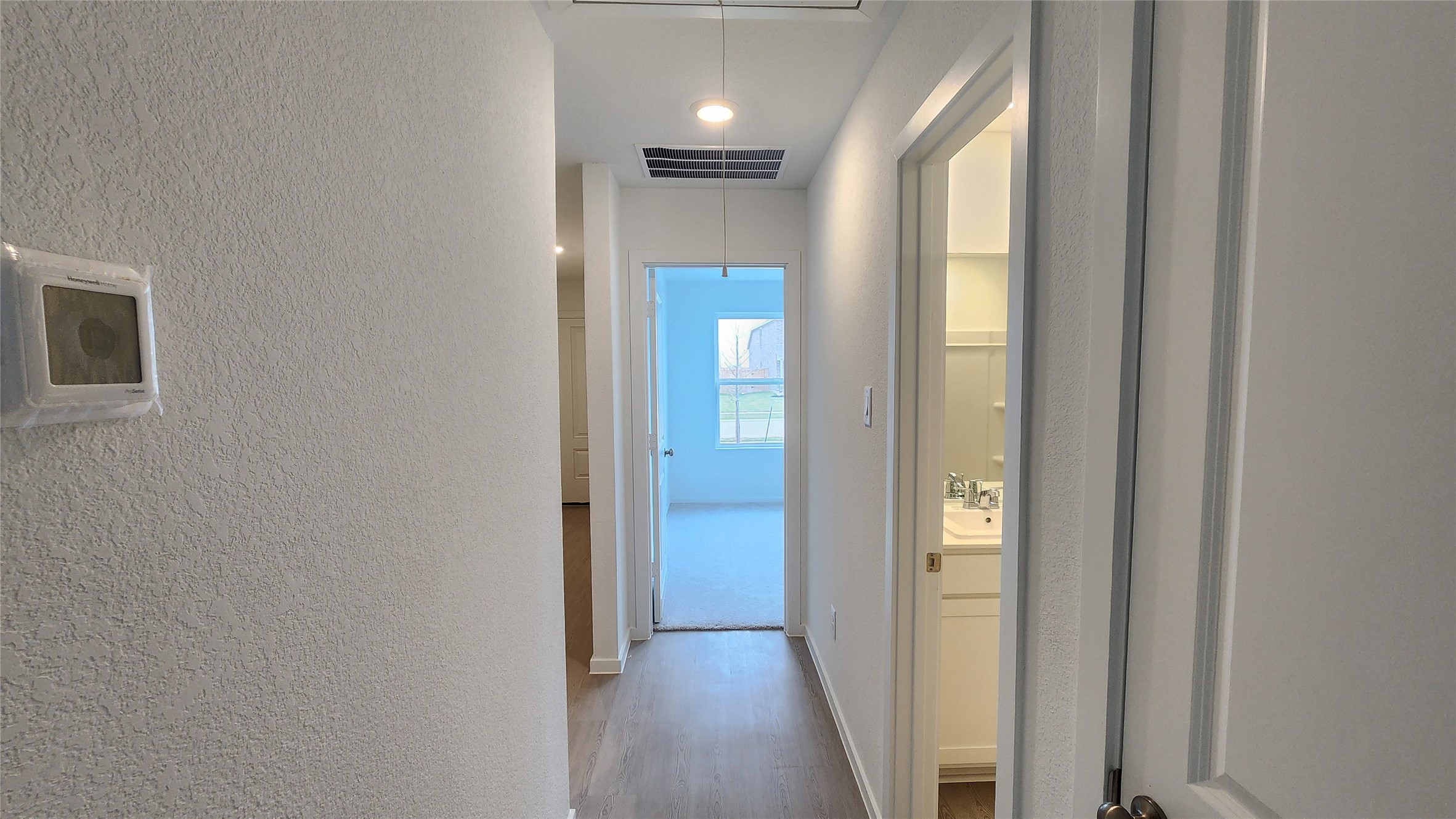16202 Rustic Prairie Drive Hockley, TX 77447 - Photo 16 of 35 a view of a hallway with wooden floor and a bathroom
