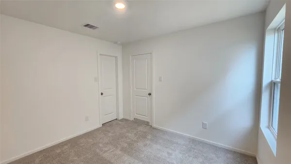 an empty room with windows and closet