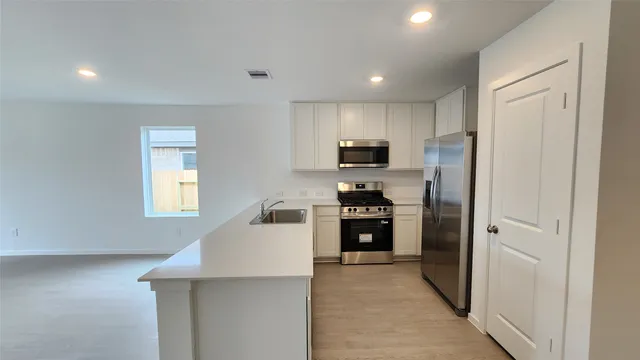 a kitchen with cabinets and stainless steel appliances