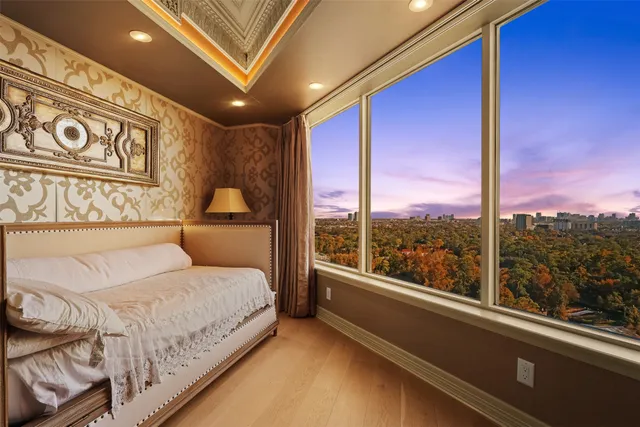 a bedroom with a large bed and a large window with outer view