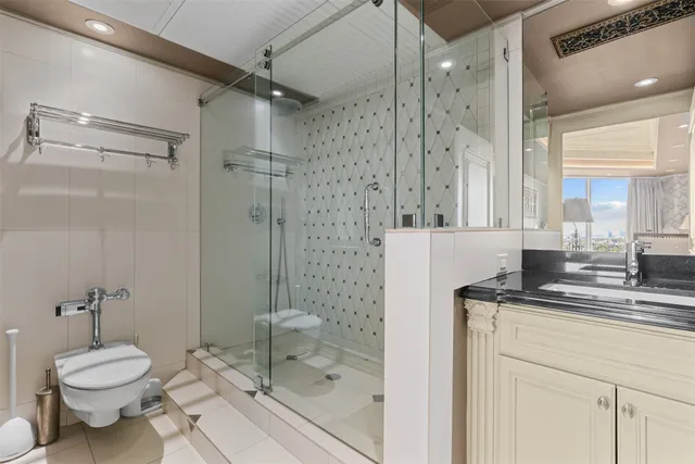 a bathroom with a granite countertop sink toilet a mirror and shower