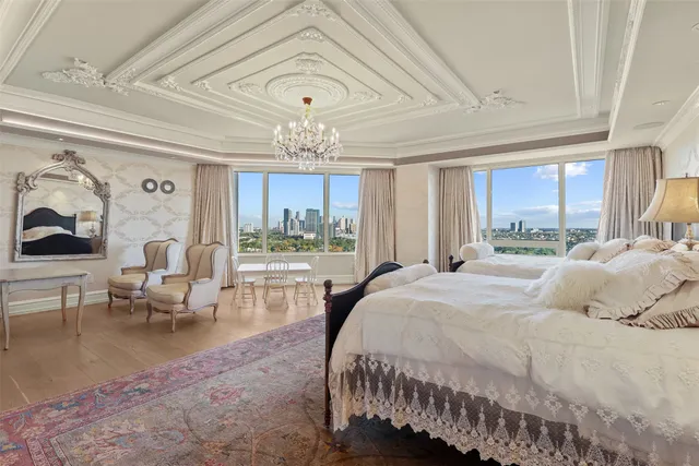 a bedroom with a bed large window couch and table