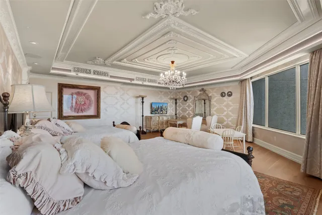 a spacious bedroom with a large bed and a chandelier