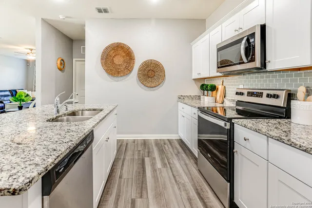 a kitchen with granite countertop wooden cabinets and a stove