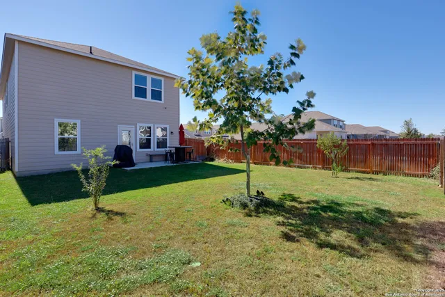 a view of a house with backyard and trees