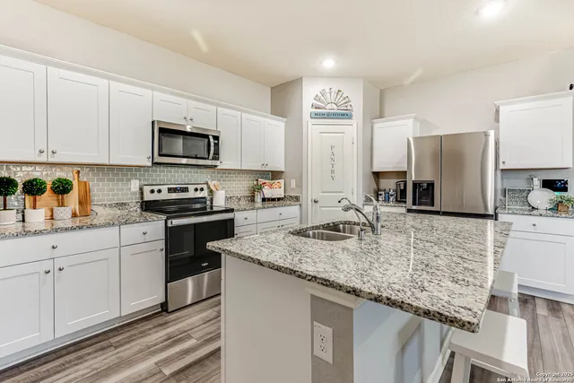 a kitchen with stainless steel appliances granite countertop a sink stove microwave and refrigerator