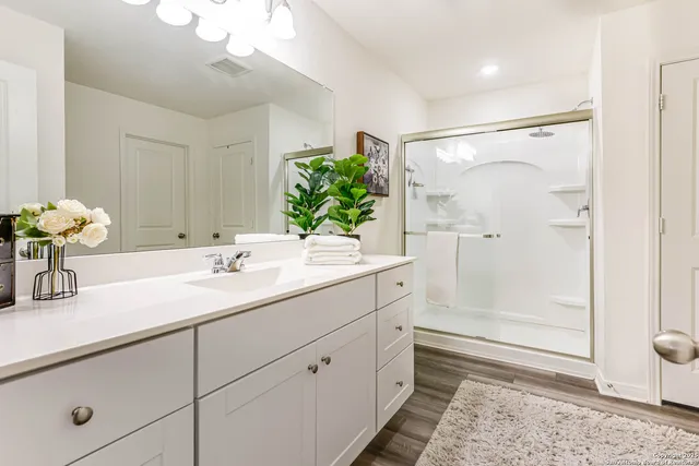 a bathroom with a shower sink and mirror