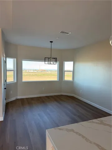 a view of an empty room window and wooden floor