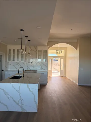 a kitchen with kitchen island granite countertop a sink and a stove