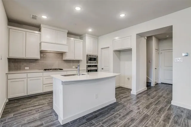 a kitchen with a sink stove and cabinets