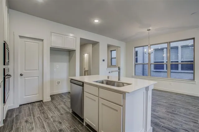 a kitchen with stainless steel appliances granite countertop a sink a stove a refrigerator and cabinets