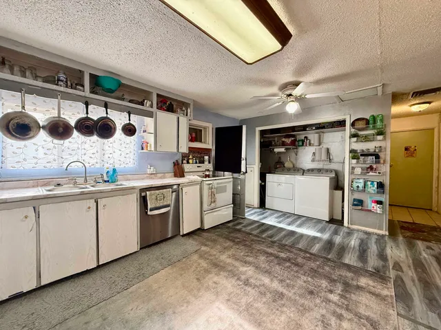 a kitchen with a sink window and white cabinets