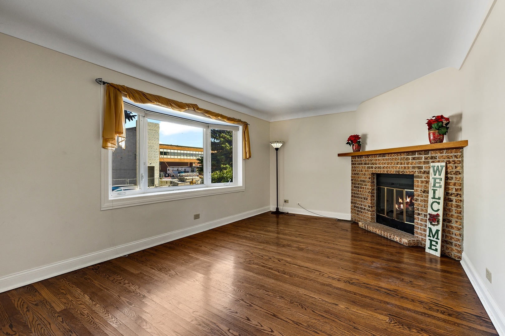 9011 24th Street Riverside, IL 60546 - Photo 3 of 22 a view of an empty room with wooden floor fireplace and a window