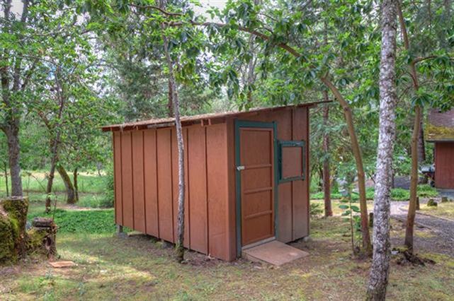 7192 Lower River Road Grants Pass, OR 97526 - Photo 19 of 30 a view of a backyard with large trees and wooden fence