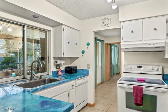 a kitchen with granite countertop a sink and a stove next to a window