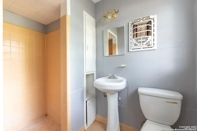 a bathroom with a toilet sink and mirror