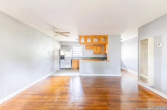 a view of a kitchen with a fridge and wooden floor