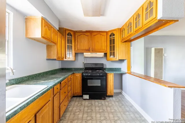 a kitchen with stainless steel appliances granite countertop a stove a sink and a refrigerator