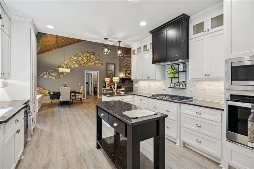305 Wilkie Road Ball Ground, GA 30107 - Photo 17 of 37 a kitchen with granite countertop a sink stove and cabinets