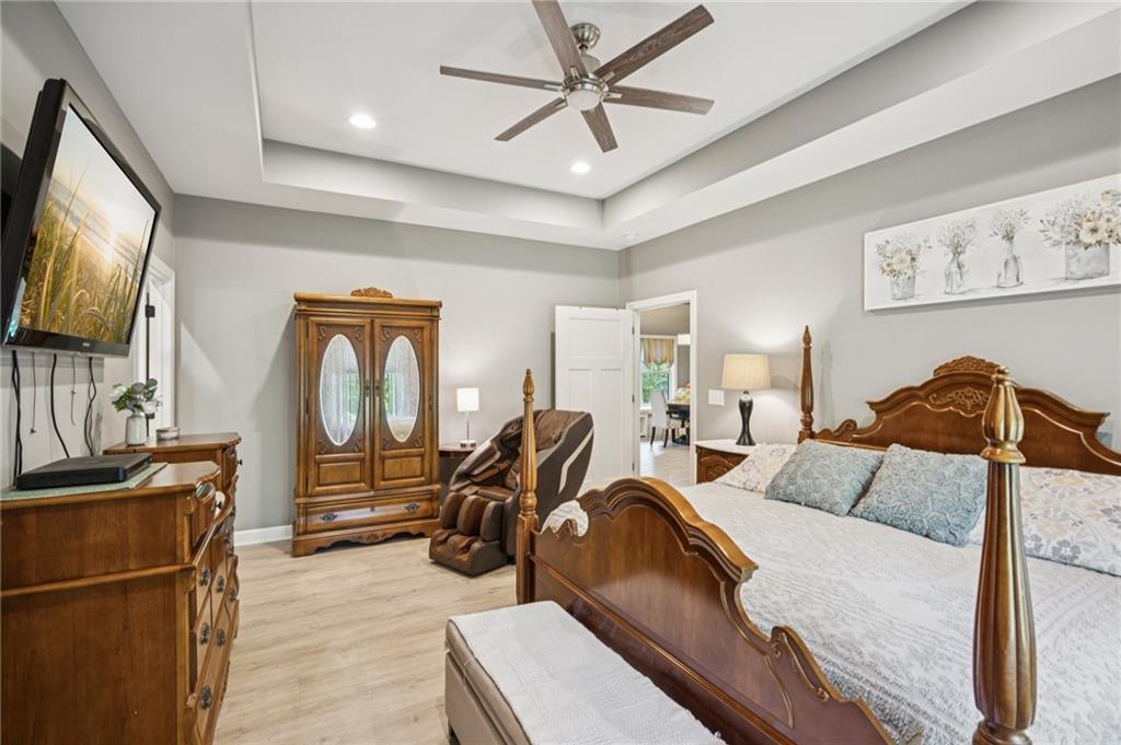 305 Wilkie Road Ball Ground, GA 30107 - Photo 19 of 37 a bedroom with a bed a couch and a flat tv screen on the dresser