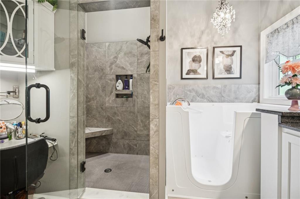 305 Wilkie Road Ball Ground, GA 30107 - Photo 21 of 37 a bathroom with a tub sink and mirror