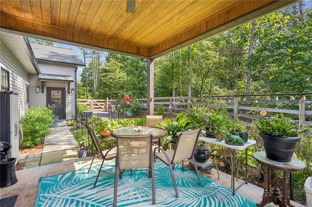 305 Wilkie Road Ball Ground, GA 30107 - Photo 30 of 37 a view of a patio with table and chairs potted plants with wooden floor