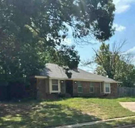 a front view of house with yard and trees in the background