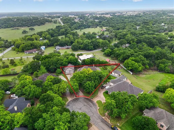 an aerial view of green landscape with trees houses and mountain view