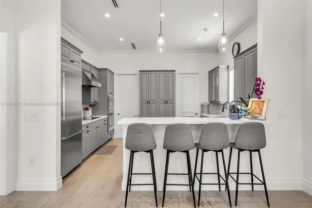 a kitchen with a sink a center island cabinets and stainless steel appliances