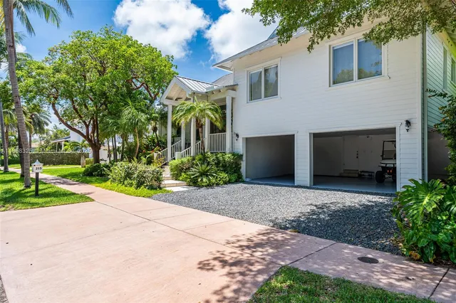 a view of a house with a yard and large tree