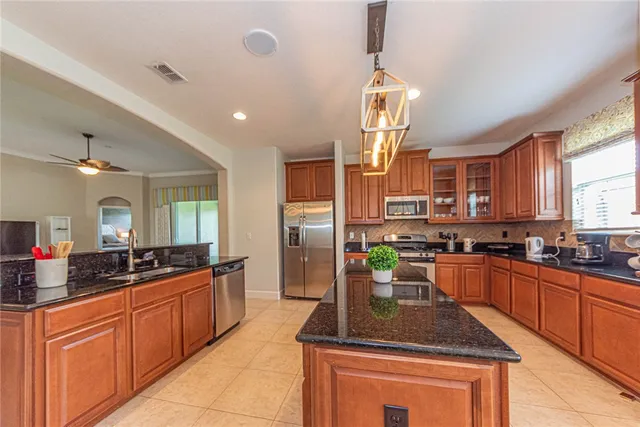 a kitchen with stainless steel appliances granite countertop a sink a stove and a wooden floors