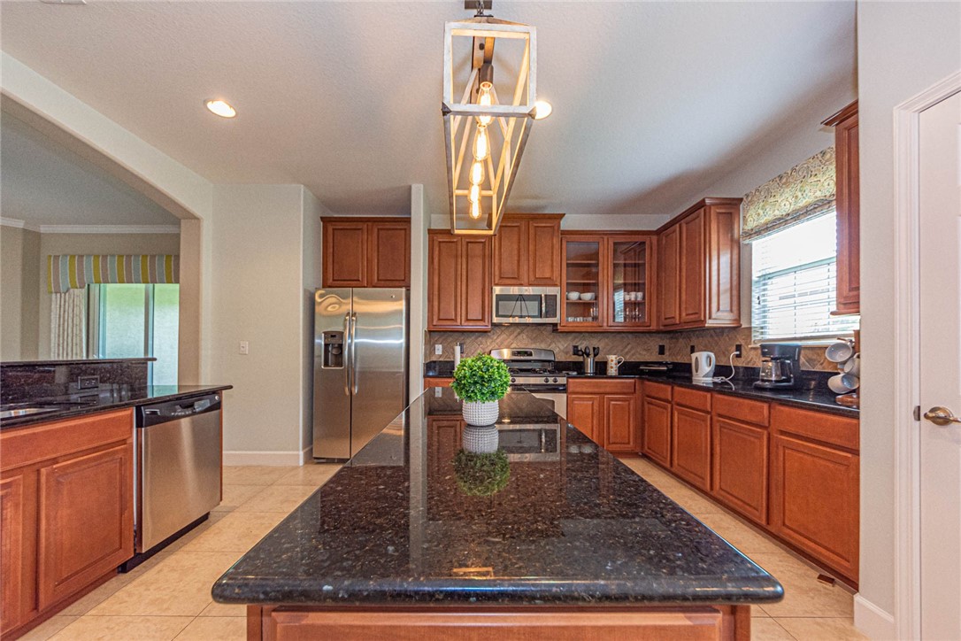 4250 Diamond Square Vero Beach, FL 32967 - Photo 10 of 33 a kitchen with stainless steel appliances granite countertop sink stove top oven and cabinets