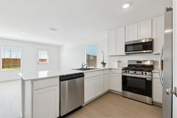 a kitchen with cabinets stainless steel appliances and a counter space