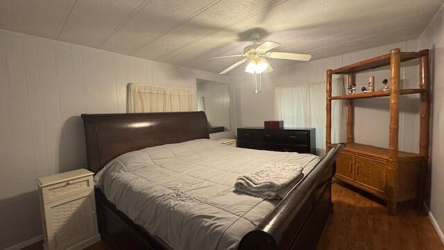 7148 Southeast Seahawk Street Hobe Sound, FL 33455 - Photo 14 of 28 a bedroom with a bed and a chandelier