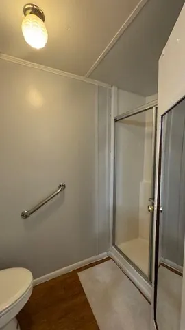 a white toilet sitting next to a shower