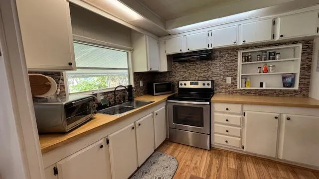 a kitchen with granite countertop white cabinets and white appliances