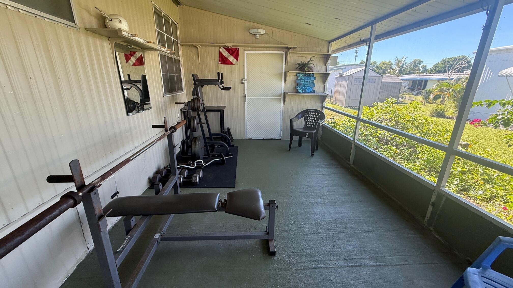 7148 Southeast Seahawk Street Hobe Sound, FL 33455 - Photo 28 of 28 a view of gym equipment with window and furniture