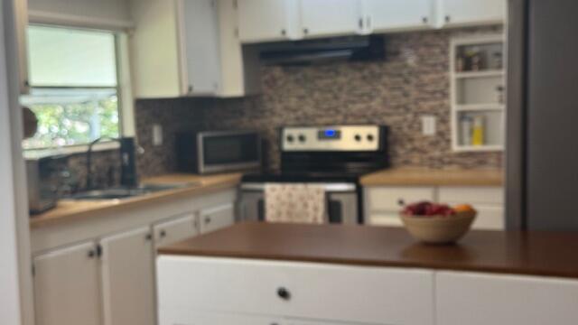 7148 Southeast Seahawk Street Hobe Sound, FL 33455 - Photo 4 of 28 a kitchen with a sink and a microwave