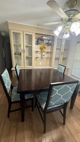 a living room with table chairs and wooden floor