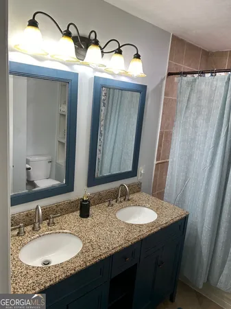 a bathroom with a granite countertop sink and mirror
